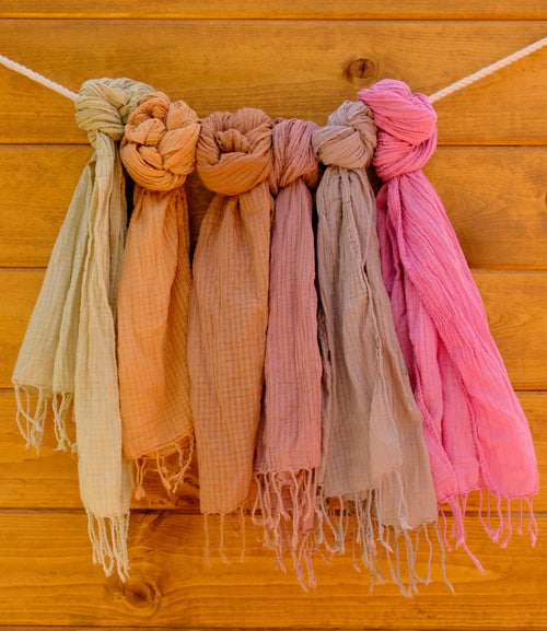 Set of colorful scarves hanging against a wooden background