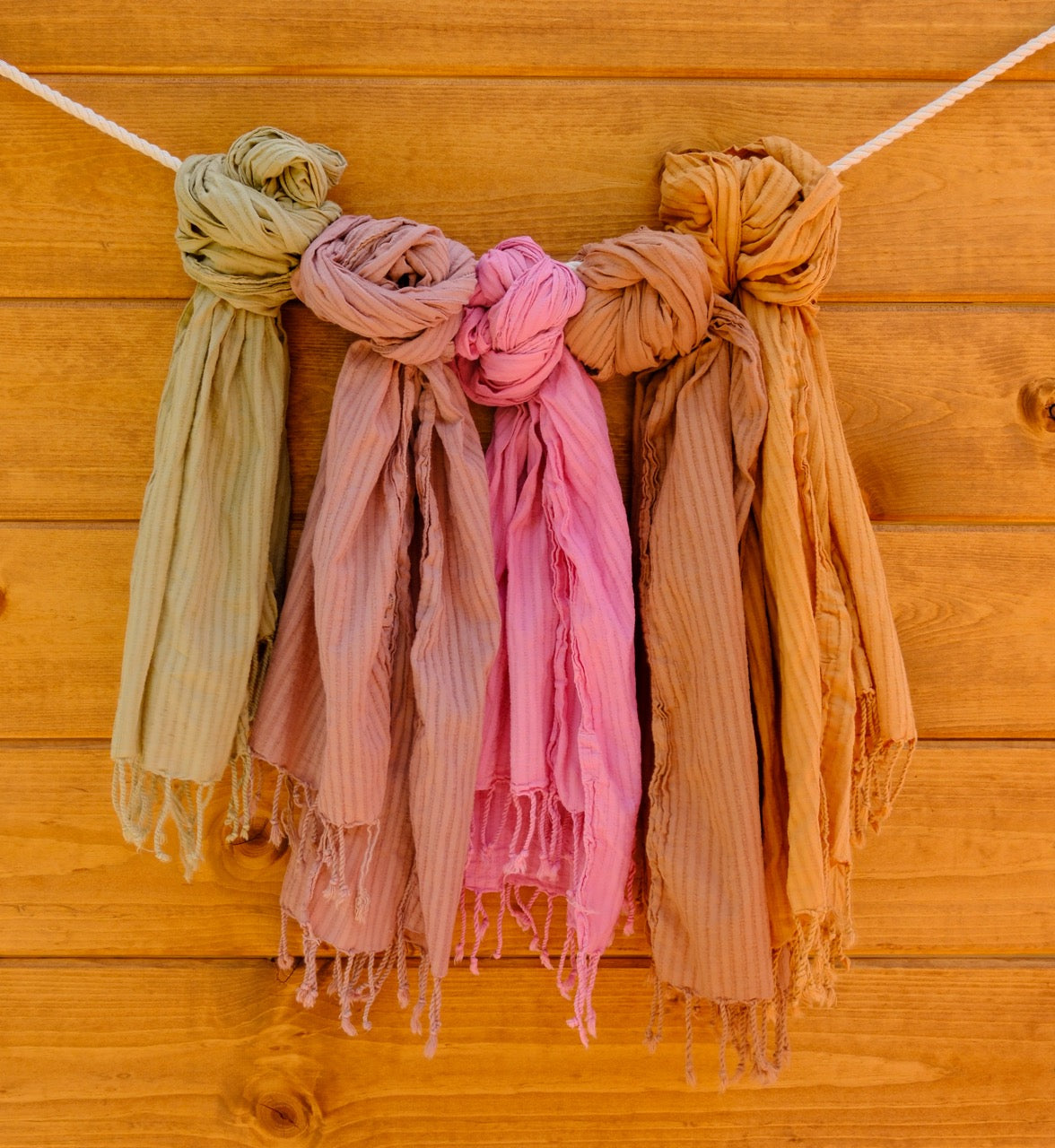scarves in hanging against a wooden background