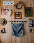 Wooden wall with mounted deer antlers, a wreath, and various framed pictures.