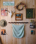 Wooden wall with decorative items including a deer skull, wreath, and framed pictures.
