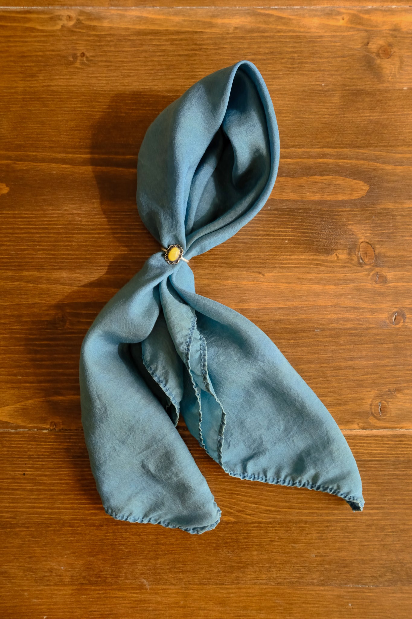 darkest green-blue scarf on a wooden surface