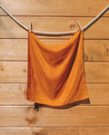 Dark orange scarf hanging on a wooden wall