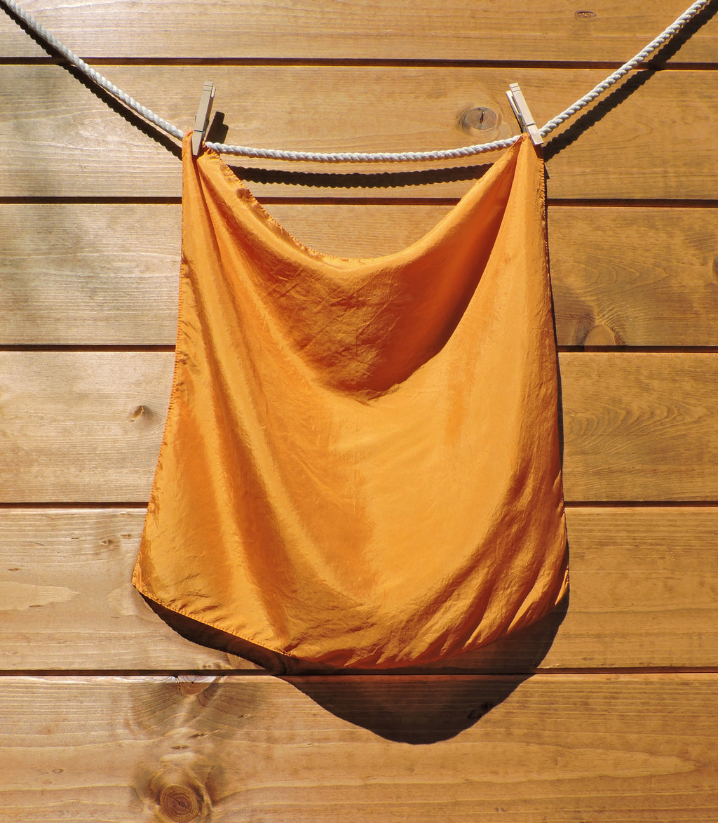 Light orange scarf hanging on a wooden wall