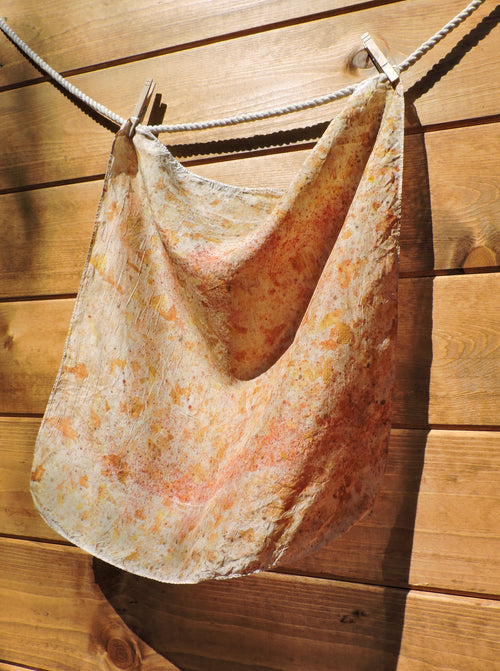 Silk scarf with floral pattern hanging on a wooden wall