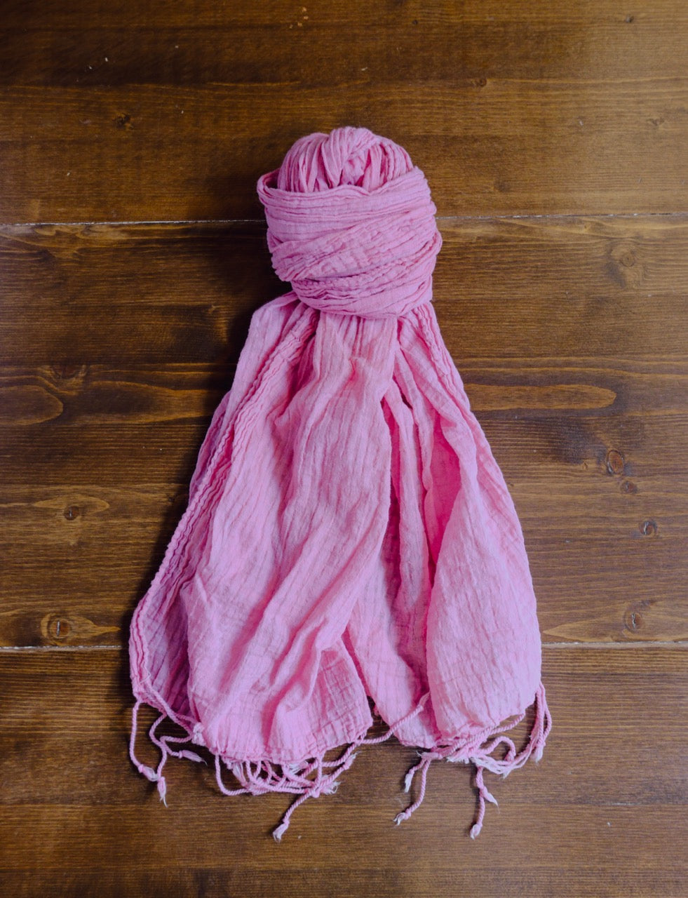 Pink scarf on a wooden surface