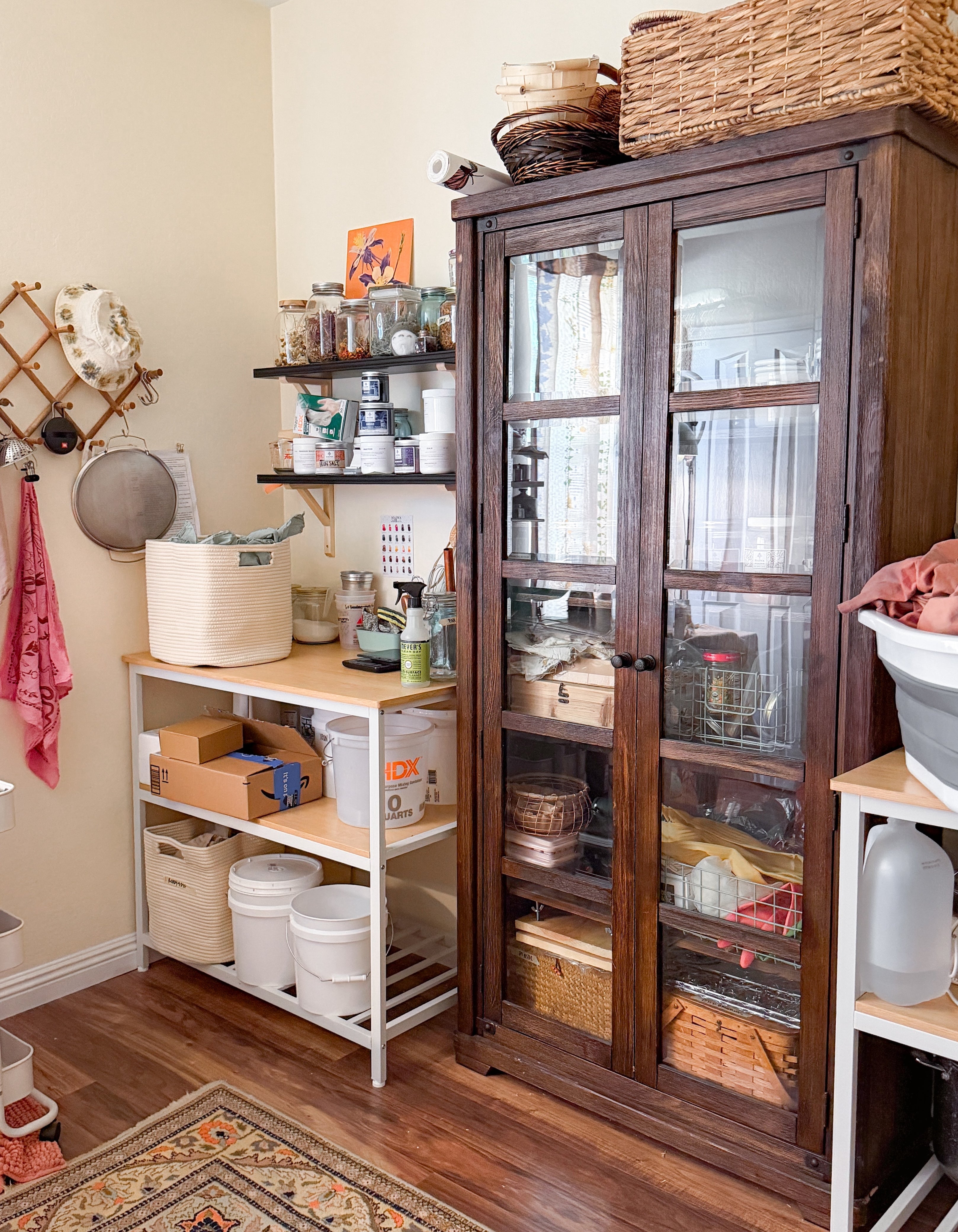 Storage room with wooden cabinet, shelves, and various storage bins used for natural dyeing.